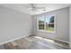 Neutral bedroom featuring wood-look floors, ceiling fan and a bright window at 3540 Owl Brow Ct, Cumming, GA 30028