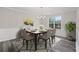 Dining room with gray wood floors, six chairs, table with chandelier and natural light at 3540 Owl Brow Ct, Cumming, GA 30028