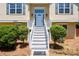 Close-up of a home's entrance, showcasing a well-maintained yard and freshly painted staircase at 3540 Owl Brow Ct, Cumming, GA 30028