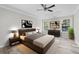 Modern main bedroom with a tray ceiling, hardwood floors, large windows, and stylish furniture at 3540 Owl Brow Ct, Cumming, GA 30028