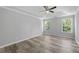Spacious primary bedroom with wood-look floors, tray ceiling, and two windows at 3540 Owl Brow Ct, Cumming, GA 30028