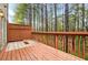 Relaxing deck area with wood railings offering a peaceful view of a wooded backyard at 3987 Howell Park Rd, Duluth, GA 30096