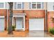 Welcoming front entrance of the townhome featuring a one-car garage and well-manicured yard at 3987 Howell Park Rd, Duluth, GA 30096