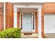 A covered front door is flanked by white pillars and sidelight windows at 3987 Howell Park Rd, Duluth, GA 30096