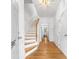 A bright hallway with wood floors, white trim, and stairs leading to the upper level and views to the back of the home at 3987 Howell Park Rd, Duluth, GA 30096