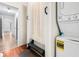 A laundry area features a stacked washer and dryer, a storage bench and a doorway to other parts of the home at 3987 Howell Park Rd, Duluth, GA 30096