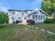 Two-story home showcasing a lush backyard with stepping stones leading to a patio and sunroom at 2875 Oak Meadow Dr, Snellville, GA 30078