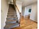 Carpeted staircase with wooden banister and railing leading to upper level, hardwood landing at 2875 Oak Meadow Dr, Snellville, GA 30078