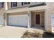 Close-up of a townhome entrance featuring a single-car garage, and a brick-framed front door at 2990 Fareed St, Douglasville, GA 30135