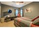 Bedroom features gray walls, a ceiling fan, a wall-mounted television, and a bed with a plaid comforter at 135 Clear Spring Lane, Oxford, GA 30054