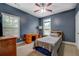 Bedroom with blue walls, a ceiling fan, two windows, and a desk with a lamp at 135 Clear Spring Lane, Oxford, GA 30054