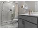Bathroom featuring marble shower with glass doors, gray vanity, and modern fixtures at 4651 Eddibunn Se Dr, Smyrna, GA 30080