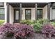 A townhome exterior features a covered porch, black trim, and garden at 4651 Eddibunn Se Dr, Smyrna, GA 30080