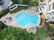 Overhead view of modern pool with geometric design and poolside seating surrounded by lush greenery and trees at 750 Park Ne Ave # 18S, Atlanta, GA 30326