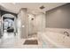 This bathroom offers an all-in-one shower and tub combo with marble walls and gray tile at 750 Park Ne Ave # 18S, Atlanta, GA 30326