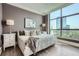 Cozy bedroom features a large window offering city views, plus hardwood floors and neutral decor at 750 Park Ne Ave # 18S, Atlanta, GA 30326