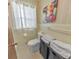 Bathroom featuring a toilet, window, white tile, towels, and a framed cow picture at 1955 Starr Sw Rd, Conyers, GA 30094