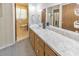 Bathroom with a large vanity, cabinets, mirror, and a connecting door to another area at 1955 Starr Sw Rd, Conyers, GA 30094