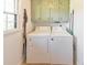 Functional laundry room with a washer and dryer, overhead cabinets, and natural light at 1955 Starr Sw Rd, Conyers, GA 30094