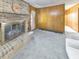 Cozy living room showcasing a brick fireplace, wood paneling, and neutral carpet at 1955 Starr Sw Rd, Conyers, GA 30094