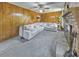Spacious living room features wood paneling, brick fireplace, plush carpet, and a comfortable light gray sectional at 1955 Starr Sw Rd, Conyers, GA 30094