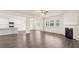 Spacious open-concept living area with hardwood floors, fireplace, and kitchen area at 300 Aspen Valley Dr, Loganville, GA 30052