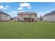 View of the home's rear exterior showcasing a spacious backyard and covered patio area with comfortable seating at 8033 Louis Dr, Locust Grove, GA 30248