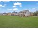 Exterior view highlighting the large backyard, covered patio, and surrounding homes in the neighborhood at 8033 Louis Dr, Locust Grove, GA 30248