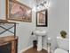 Stylish half bathroom with updated fixtures, unique artwork, and a pedestal sink at 8033 Louis Dr, Locust Grove, GA 30248