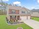 Charming two-story home with a landscaped yard and two-car garage and mixed brick and siding facade at 8033 Louis Dr, Locust Grove, GA 30248