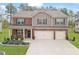 Charming two-story home with a landscaped yard and two-car garage and mixed brick and siding facade at 8033 Louis Dr, Locust Grove, GA 30248