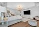 Bright main bedroom featuring tray ceiling, hardwood floor, a chandelier, and white trim at 8033 Louis Dr, Locust Grove, GA 30248