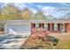 Charming single-story brick home featuring a well-maintained front yard, garage, and mature landscaping at 831 Sinyard Rd, Lithia Springs, GA 30122