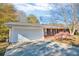 Attached two-car garage with a long driveway and manicured landscaping at the front of the house at 831 Sinyard Rd, Lithia Springs, GA 30122