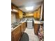 Compact kitchen with wooden cabinets, electric stove, and white tiled floor at 831 Sinyard Rd, Lithia Springs, GA 30122