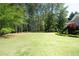 Large backyard with beautiful green grass and perimeter landscaping with mature trees at 84 Nw Gloster Nw Rd, Lawrenceville, GA 30044