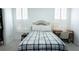 Bright bedroom with a cozy plaid blanket, white walls, and natural light from shuttered windows at 84 Nw Gloster Nw Rd, Lawrenceville, GA 30044