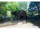 A metal fence encloses the backyard with a brown building and mature trees at 84 Nw Gloster Nw Rd, Lawrenceville, GA 30044