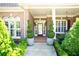 Charming brick home entrance with potted spiral topiaries and covered front porch at 84 Nw Gloster Nw Rd, Lawrenceville, GA 30044