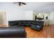 Open-concept living area with hardwood floors, kitchen view, and a dark leather sectional at 84 Nw Gloster Nw Rd, Lawrenceville, GA 30044