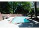 Backyard pool area with a brick wall perimeter, surrounded by mature trees at 84 Nw Gloster Nw Rd, Lawrenceville, GA 30044