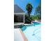 Inviting in-ground pool with a spa, lush landscaping, and brick accents for backyard enjoyment at 84 Nw Gloster Nw Rd, Lawrenceville, GA 30044