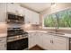 Close up of a kitchen with stainless steel appliances, white cabinets, and a sink with a view at 2183 Seaman Cir, Atlanta, GA 30341
