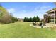 Expansive backyard featuring a fire pit area with seating, lush lawn, and mature trees at 260 Millstone Pkwy, Woodstock, GA 30188