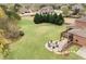 Aerial view of a large backyard featuring a deck, fire pit area, expansive lawn, and mature trees at 260 Millstone Pkwy, Woodstock, GA 30188