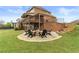 Spacious backyard featuring a stone fire pit with seating, a covered patio, and well-maintained landscaping at 260 Millstone Pkwy, Woodstock, GA 30188