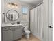 Cozy bathroom with vanity, granite countertops, a toilet, and a shower with patterned curtain at 260 Millstone Pkwy, Woodstock, GA 30188