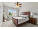 Comfortable bedroom with a large window, ceiling fan, nightstands, and wood furnishings at 260 Millstone Pkwy, Woodstock, GA 30188