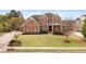 Stately brick home boasts a manicured front lawn and symmetrical landscaping, creating a welcoming curb appeal at 260 Millstone Pkwy, Woodstock, GA 30188