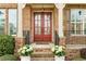Elegant front entrance with brick columns, double doors, and potted white flowers adding charm at 260 Millstone Pkwy, Woodstock, GA 30188